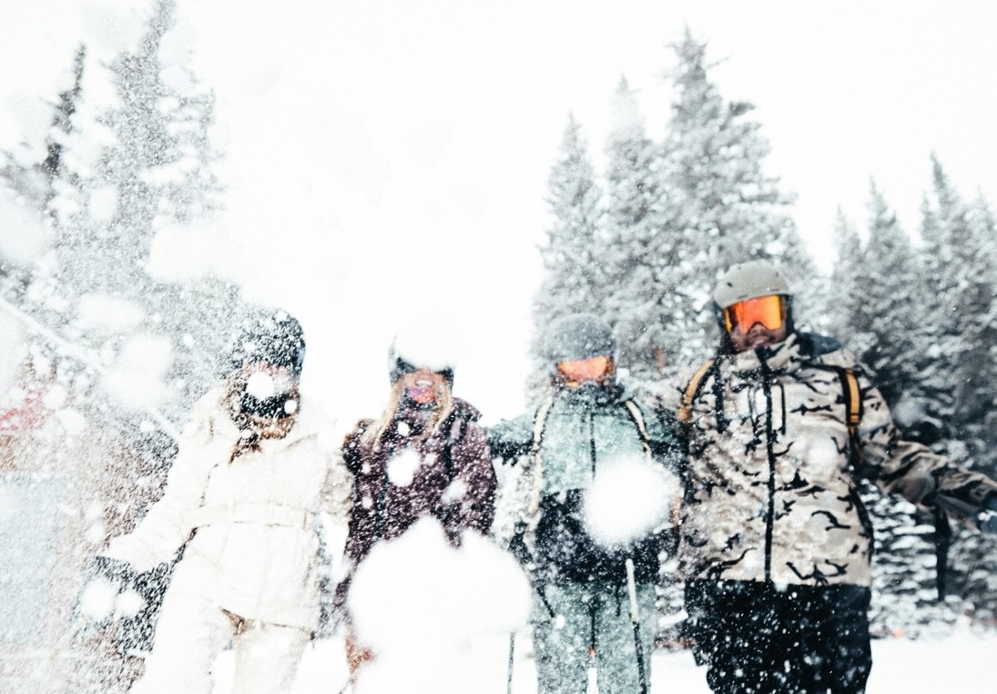 Four skiers standing together in falling snow